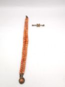 A Victorian double strand coral bead bracelet with yellow metal clasp (tongue damaged) along with