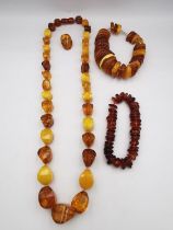 A collection of amber jewellery, including a long Baltic and butterscotch amber bead necklace with