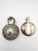Two silver perfume bottles. A Victorian silver hinged two halved repousse perfume bottle holder with