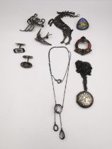 A collection of silver jewellery, including a silver repousse locket on white metal chain, an