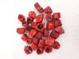 A collection of thirty red branch coral beads.