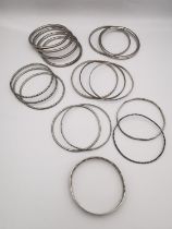 A collection of seventeen silver bangles, including a set of four textured thin bangles by Wai Kee