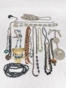 A collection of costume jewellery, including a brass butterfly necklace, a venetian foil necklace, a