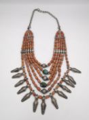 A 19th century Indian coral and turquoise bead multi strand collar necklace with white metal charms,