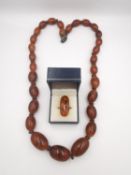 A long faux amber plastic graduated bead necklace along with a boxed white metal Baltic amber