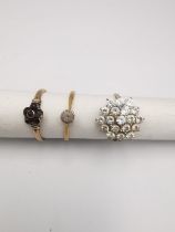 Three 9ct yellow gold rings, a cubic zirconia cluster ring, a Victorian garnet set flower ring and a