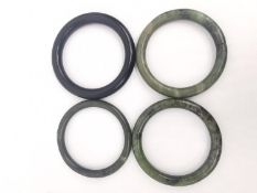 Four Chinese jade bangles, one almost black.