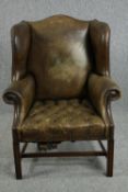 Wingback chair, George III style mahogany in leather upholstery.