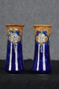 A pair of Royal Doulton vases. Floral decoration with a deep blue glaze. W.24 W.11 cm.