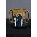 A double handled Royal Doulton tankard designed by Charles Noke. Depicting a monk and fishmonger.