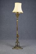 A tall brass floor lamp measuring 177 cm high. With a shade and decorated base. Originally an oil