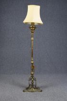 A tall brass floor lamp measuring 177 cm high. With a shade and decorated base. Originally an oil