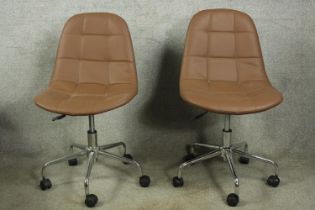 A pair of vintage style faux leather swivel chairs.