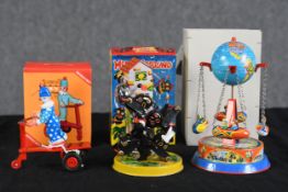 A collection of three Russian tin litho wind up toys. To include, a clown, dog and a swinging