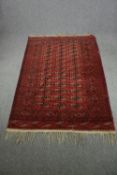 Carpet, Bokhara, gul motifs on burgundy field. L.215 W.140cm.
