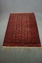 Carpet, Bokhara, gul motifs on burgundy field. L.215 W.140cm.