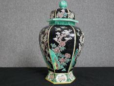 A late 20th century Chinese hexagonal form lidded ceramic urn with hand painted blossom tree and