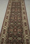 A long Tabriz design runner, silk and wool, with profuse flowerhead and palmette design within