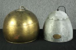 Two ceiling lamps. One made from metal and with an industrial look about it. With a brass label