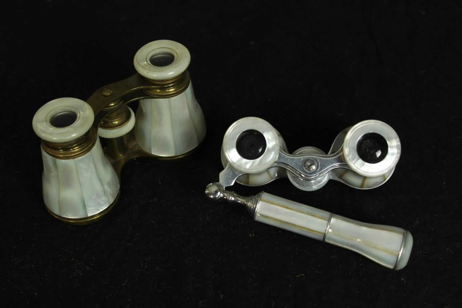 Two pairs of mother of pearl opera glasses. One with a telescopic handle. Each measure W.12 D.7 cm.