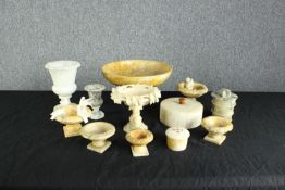 A collection of twelve alabaster pieces including birdbaths, a cherub, dish, urn and a lidded pot.
