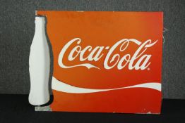 A vintage Coca Cola sign. An interesting design with a spinning coke bottle silhouette. Some