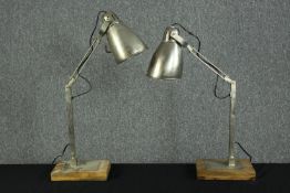 Two metal anglepoise lamps on wooden stands. Mid twentieth century style. H.80cm.