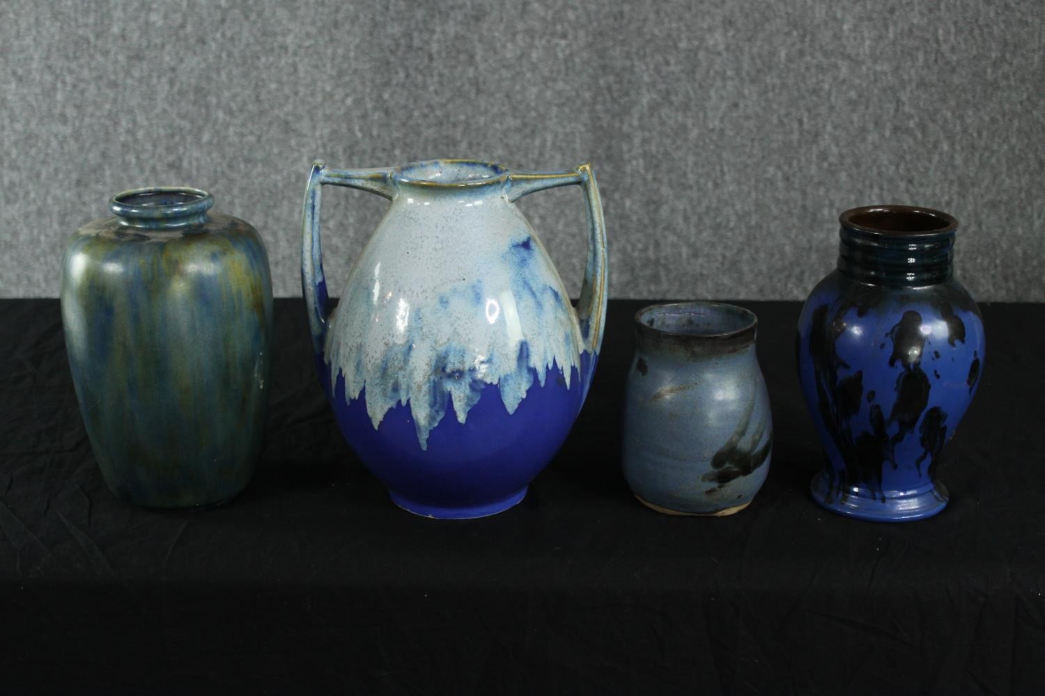 A two-handled pottery vase, by Alpho with blue/green drip glaze on a blue ground along with three