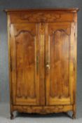 Armoire, 19th century French provincial chestnut with foliate carving on squat cabriole supports.
