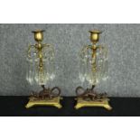 A pair of candleholders. Bronze dragons supporting gilt metal trunks and decorated with hanging