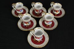 A French six person hand painted fine china coffee set with maroon ground, floral design and