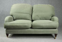 Sofa, contemporary in Howard style. H.93 W.152 D.95cm. (One brass wheel missing).