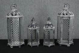 Two pairs of contemporary painted storm lanterns each pair with a different size. Both featuring