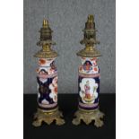 A pair of early 20th century Imari style hand painted porcelain and brass converted oil lamps