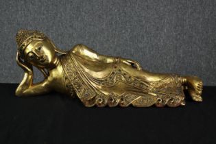 Sleeping Buddha. Carved and painted in gilt. Highly detailed and with the robes intricately inlaid