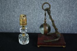 A glass ball suspended by an anchor. The glass ball would once have held a clock. Not present. Also,