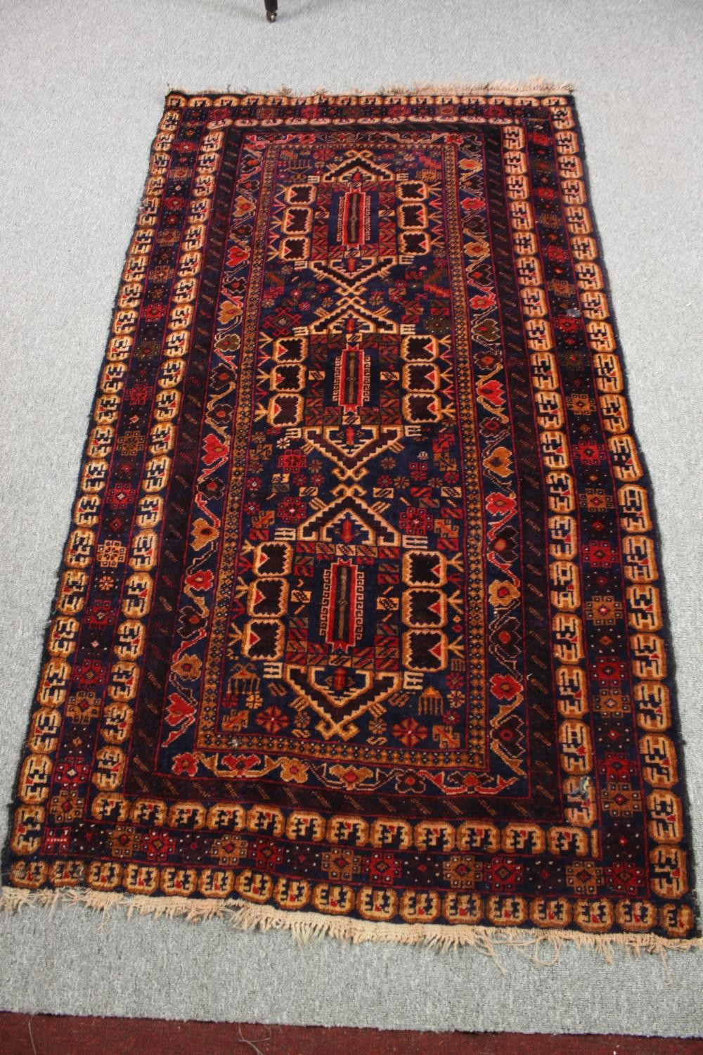 A Kazak rug with triple medallions in multiple stylised borders. L.200 W.110cm.