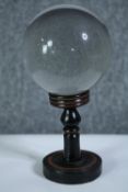 A crystal glass fortune tellers ball on a turned ebonised stand. Early twentieth century. H.20 Dia
