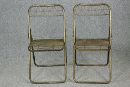 A pair of metal folding chairs.
