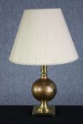 Brass table lamp. With a globe design to the stem with embossed floral decoration. Probably