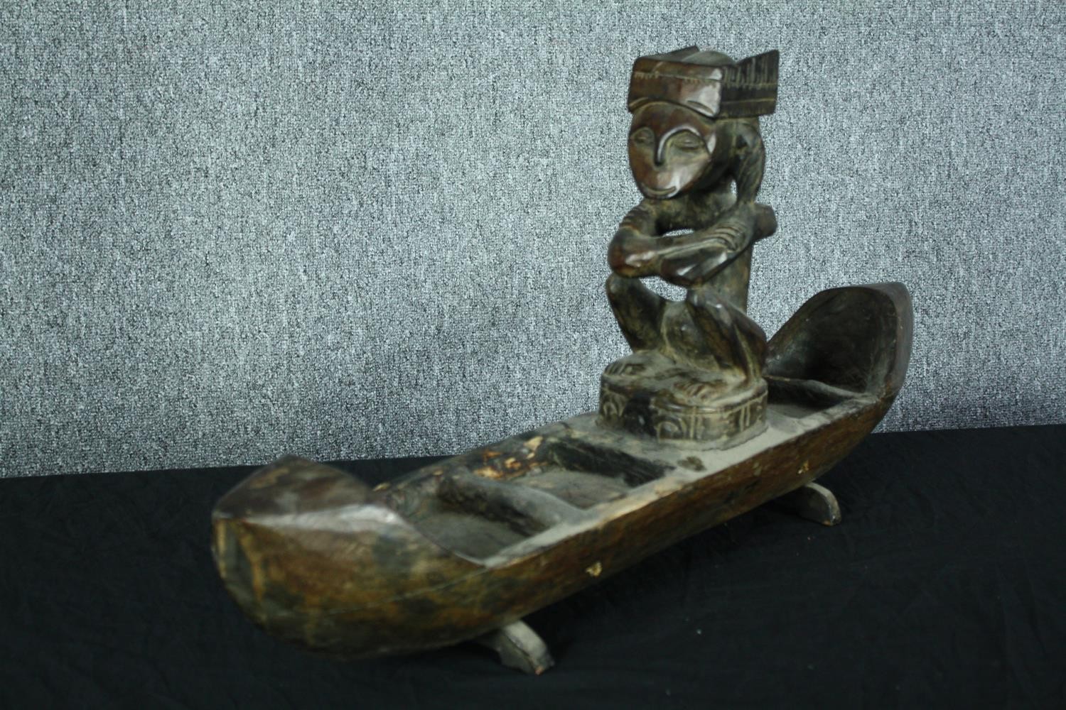 A large carved wooden canoe with a serene looking seated figure. H.39 W.80 cm. - Image 3 of 5