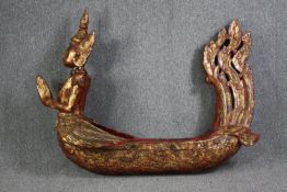 A large carved Buddha in a boat or canoe. Gilded and decorated with small mirror tiles. H.125 W.