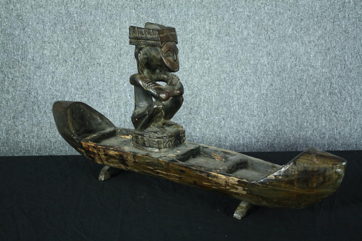 A large carved wooden canoe with a serene looking seated figure. H.39 W.80 cm. - Image 4 of 5
