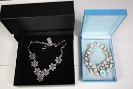 Two boxed statement articulated silver and gemstone necklaces. One of a floral design set with