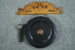 A suspended gong with a nipple boss to the centre and a carved wall support. Metal. Twentieth