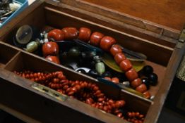 A small wooden box of costume jewellery. Tribal in style and probably early plastic.
