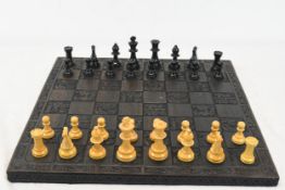 A chess set with a carved board measuring W.46 x D.46 cm.