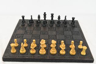 A chess set with a carved board measuring W.46 x D.46 cm.