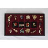 A box of eighteen brooches. A mix of designs and styles including golf and sailing. Housed in a