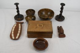 A collection of carved hardwood items to include two candle sticks, four bowls, a figure, box and